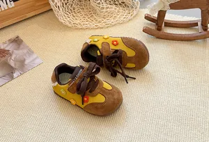 Retro yellow and brown children's German trainer shoes featuring cute knit flower details