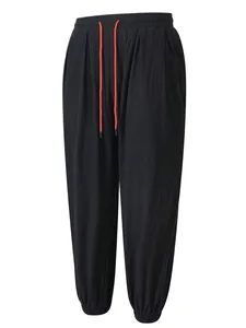 Vista detallada de los pantalones casuales de lino negro para hombre con cordón rojo.