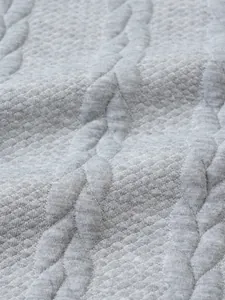 Close-up macro detail of grey jacquard knit sweater fabric with high-quality texture