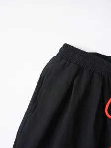 Detalle de primer plano de pantalón de algodón y lino negro con cintura elástica.