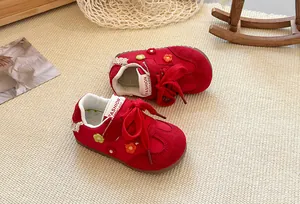 Detailed view of red suede girls' sneakers with colorful embroidered flower patterns
