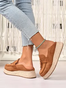 Detail view of brown suede espadrille platform loafers with a woven hemp thick sole.