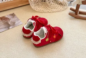 Close-up of red children's board shoes with floral decoration and lace heel detail