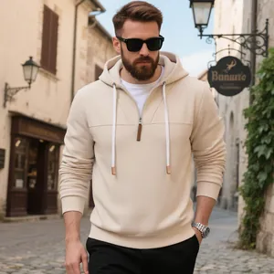 Primer plano de hombre con sudadera beige gruesa con capucha y media cremallera en calle