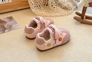 Detailed view of pink toddler trainer shoes with delicate floral and lace embroidery