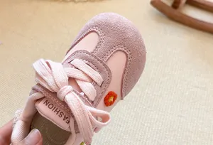 Close-up of pink girl's casual sneaker with floral embroidery and soft suede texture