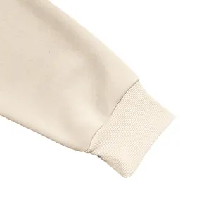 Detalle de primer plano del puño acanalado y la tela gruesa de una sudadera con capucha de felpa crema