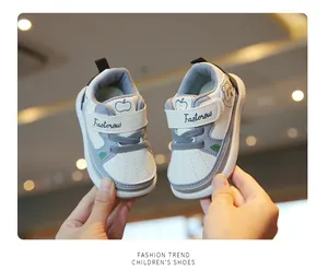 Detailed view of soft sole baby walking shoes in white and gray with cute apple prints