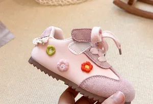 Close-up of pink children's sneakers with floral embroidery and soft soles