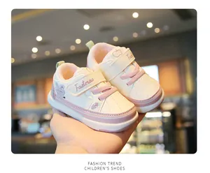Close-up detail of cute pink and white toddler walking shoes with fruit embroidery.