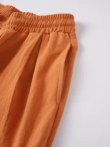 Detalle de los pantalones de lino naranja para hombre con cintura elástica y bolsillo.