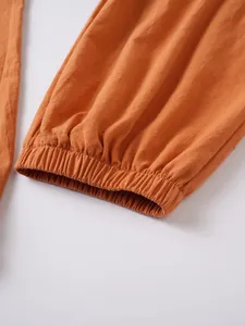 Detalle de primer plano del dobladillo elástico y la textura del pantalón de lino naranja