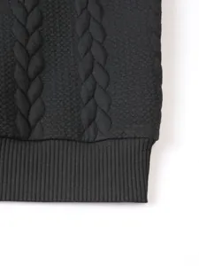 Macro view of black men's knit sweater detail with cable pattern and ribbed hem