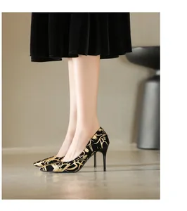 Detailansicht der schwarzen High Heels mit goldenem Muster und schmalem Stilettoabsatz.
