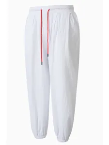 Vista frontal detallada de pantalones casuales de lino y algodón blanco con cordón de ajuste rojo.