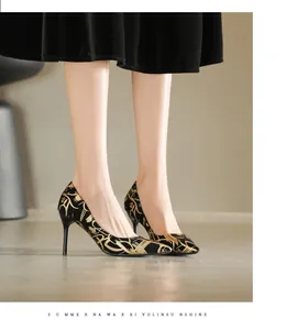 Detailansicht eleganter schwarzer Pumps mit spitzer Kappe und goldenen Mustern