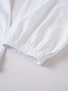Primer plano detallado de pantalones de lino blanco con puño elástico al tobillo