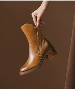 Detailed view of vintage brown leather ankle boots with chunky heel and side zipper