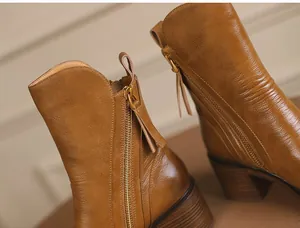 Detailed macro view of high-quality vintage brown leather ankle boots with side zipper