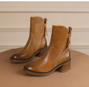 Detailed view of vintage brown leather ankle boots featuring side zipper and chunky block heel