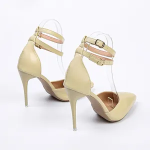 Detailed view of the stiletto heel and adjustable ankle straps of the beige sandals