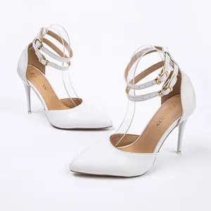 Elegant white pointed-toe stiletto pumps with double ankle straps and gold buckles