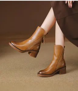 Detailed view of retro brown chunky heel ankle boots with side zipper and leather texture.
