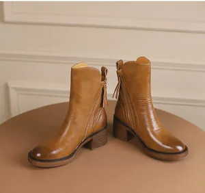 Detail shot of vintage brown leather ankle boots with side zipper and chunky heel