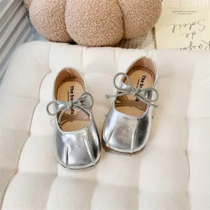Top-down view showing silver metallic Mary Jane flats for girls with cute grey bow ties