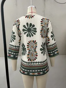 Close-up of bohemian tribal pattern on a three-quarter sleeve cream blouse