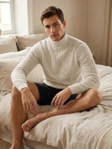 Close-up of man in white turtleneck cable-knit sweater showing intricate texture on bed