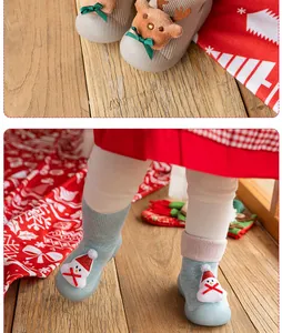 Close-up detail of festive reindeer and snowman decorations on baby walker sock shoes.