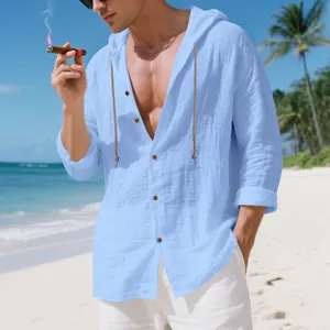 Detailansicht eines hellblauen Leinenhemdes mit Kapuze für Herren am Sandstrand.