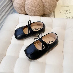 Close-up of black matte Mary Jane shoes for girls with bow tie detail and soft sole.