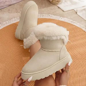 Primer plano de botas de nieve con plataforma beige, cuello de piel y detalle de lazo