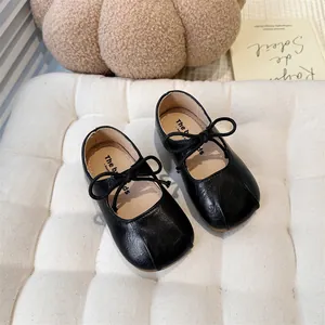 Detail showing the soft black leather and bow of these classic girls' Mary Jane flats.