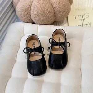 Close-up detail of black French style Mary Jane shoes for girls with bow and soft sole