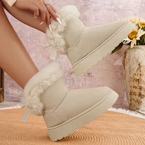 Vista detallada de botas de nieve beige con plataforma, ribete de piel sintética y lazos