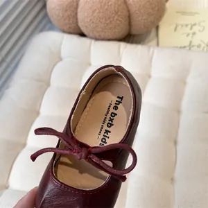Detailed macro view of dark red leather Mary Jane flat shoes for little girls with bow