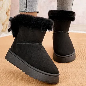 Primer plano de botas de nieve negras con plataforma y ribete de pelo sintético