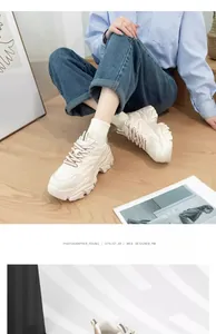 Detailed lifestyle shot of stylish women's chunky white sneakers on wooden floor