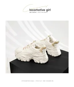 Close-up detail of cream chunky platform sneakers for women displayed on a black pedestal