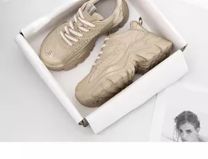 Top view of stylish beige women's chunky sneakers in white box with thick soles