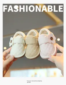 Close-up of quilted baby walking shoes with decorative flowers in three colors