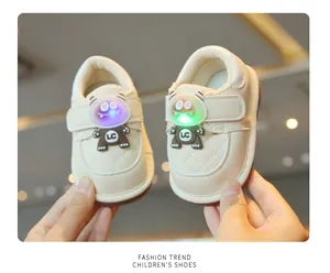 Close-up of beige toddler shoes featuring LED light-up monster design and velcro straps
