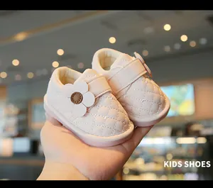 Close-up of pink quilted leather baby walking shoes with flower detail and velcro strap