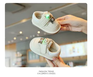 Close-up view of cream colored baby walking shoes featuring a glowing monster character