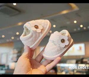 Detail of soft pink baby walking shoes with quilted leather and cute flower decoration