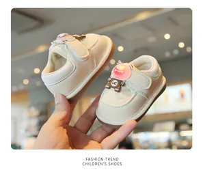 Detail of cream baby walking shoes featuring a cute light-up cartoon monster design