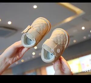 Close-up detail of quilted beige baby girl princess walking shoes with floral decoration